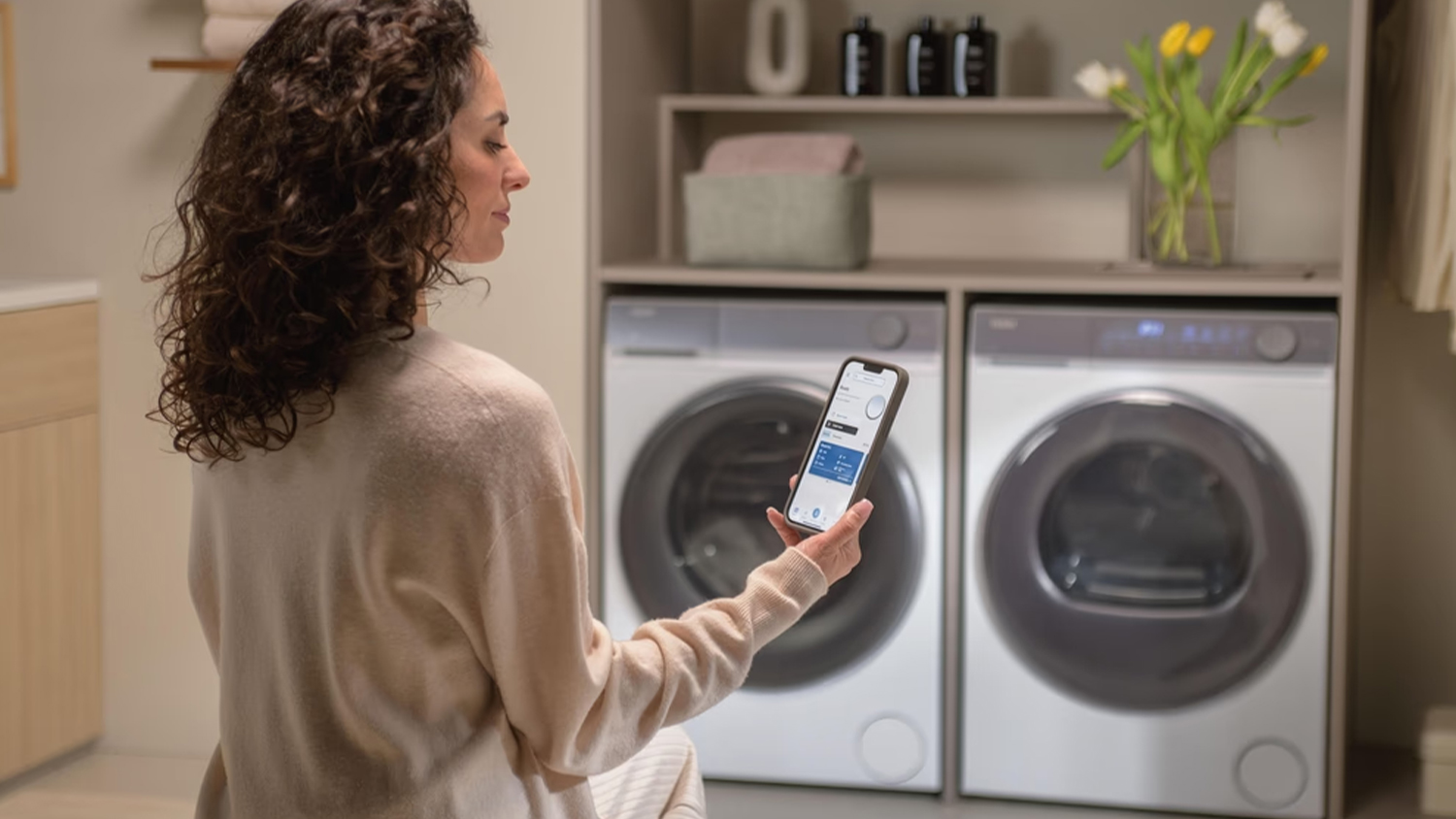 Žena ovl&aacute;d&aacute; su&scaron;ičku pr&aacute;dla Haier X SERIES 5 HD70-D357TU1 telefonem