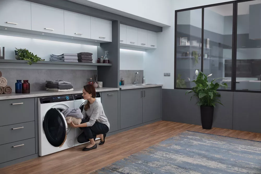 Žena vkládá prádlo do pračky se sušičkou HAIER HWD80 B14979-S_07