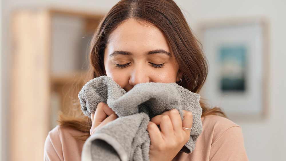 Šťastná žena čichá k čistému prádlu_03“