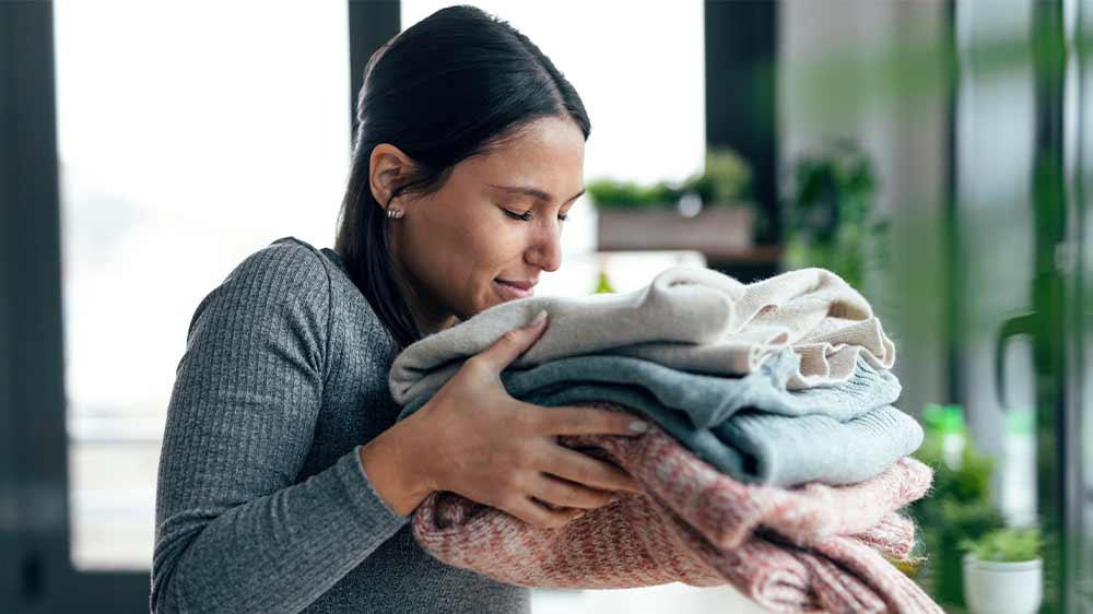 Mladá žena čichá k čistému oblečení_03