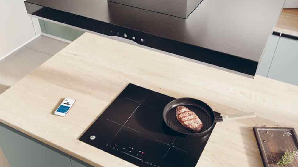 Ostrůvkový odsavač par Hoover HTSI9CBK5XWIFI instalován nad varnou deskou_02