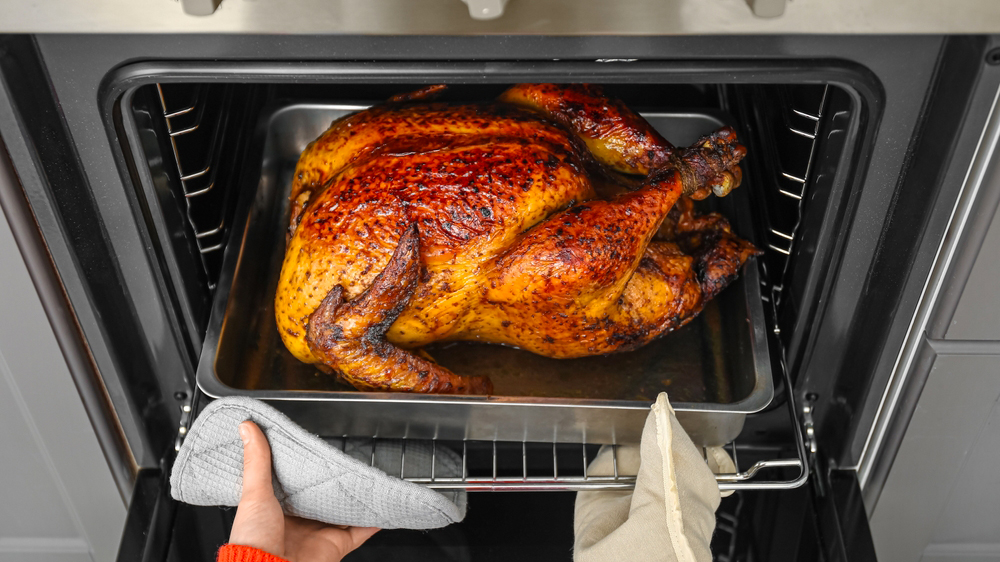 Žena vytahuje plech s krocanem z trouby_04