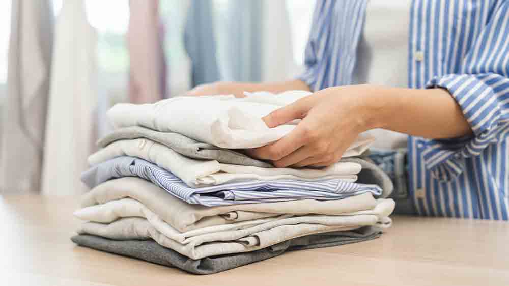 Ruce skládající prádlo