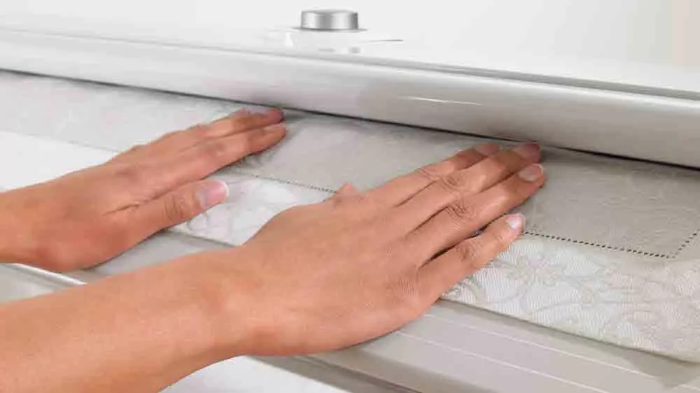 Ženské ruce přidržují prádlo v mandlu Miele B 995 D_03