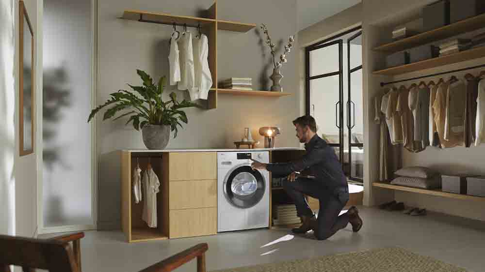 Muž obsluhuje sušičku bielizne Mielle TWH 780 WP_05