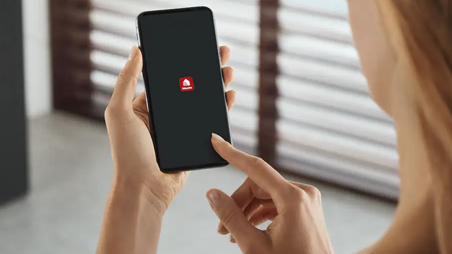 Žena použ&iacute;vaj&iacute;c&iacute; aplikaci v telefonu