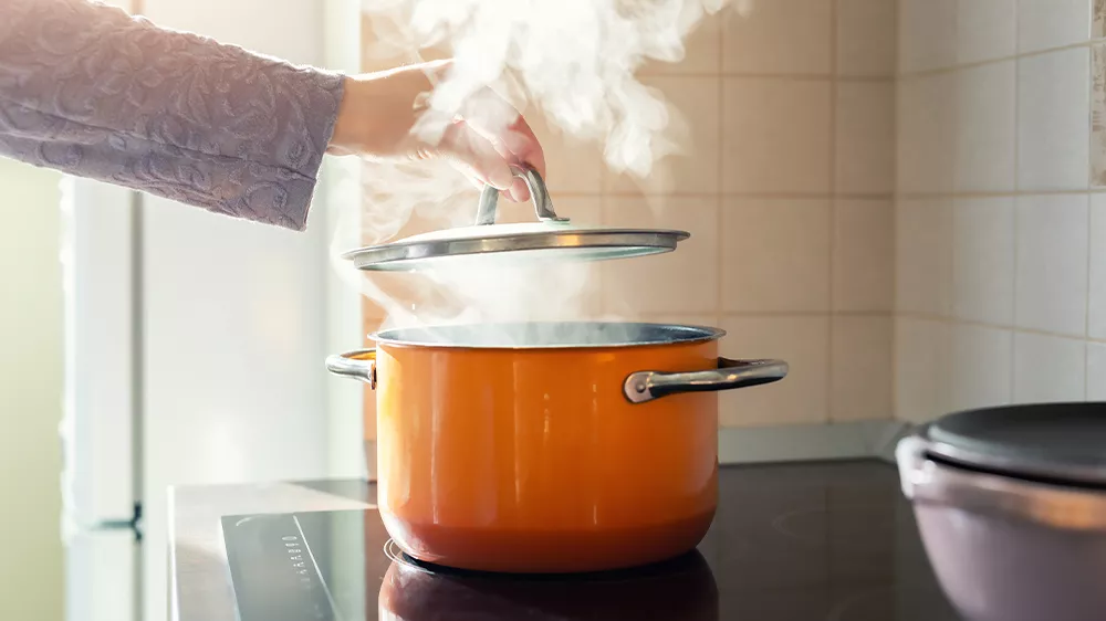 Ruka zvedaj&iacute;c&iacute; pokličku z hrnce z kter&eacute;ho odch&aacute;z&iacute; p&aacute;ra do odsavače par MORA OP 530 W_03