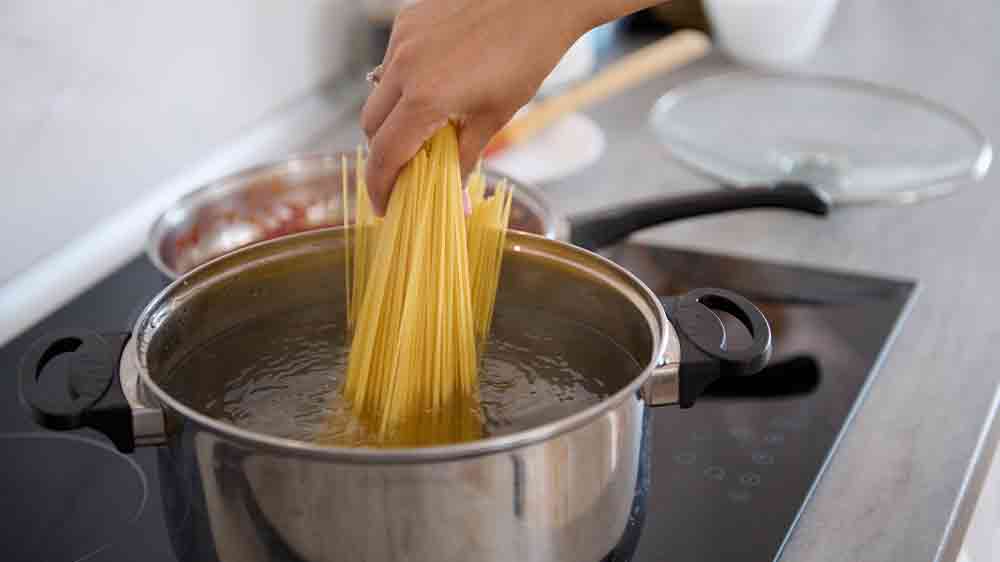 Žena dává vařit špagety do vroucí vody_02