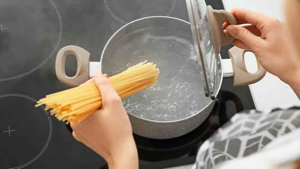 Žena dává špagety do vroucí vody_04