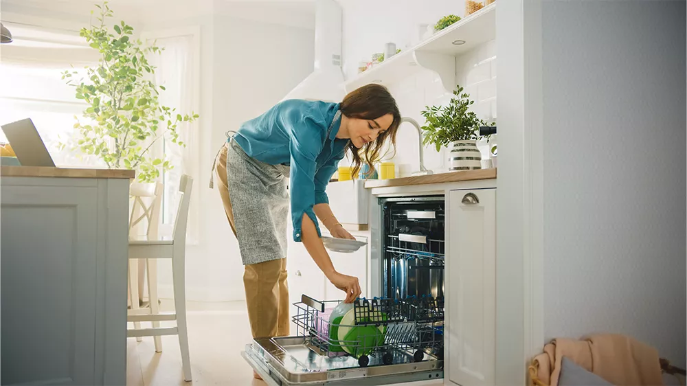 Žena ukl&aacute;d&aacute; n&aacute;dob&iacute; do myčky Philco PD 108 DTBIT_02
