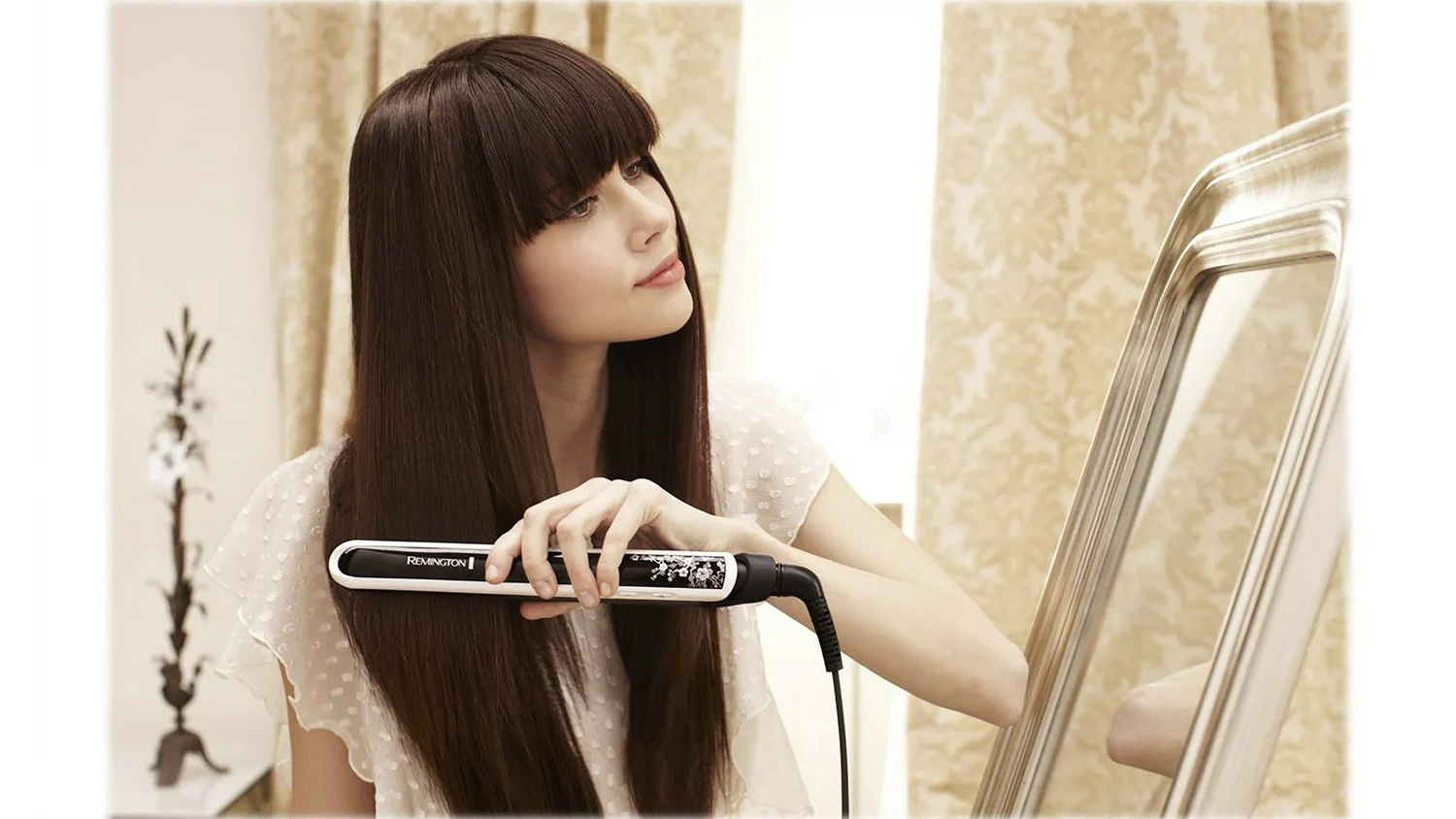 Žena upravuj&uacute;ca si vlasy žehličkou Remington S9500 Pearl