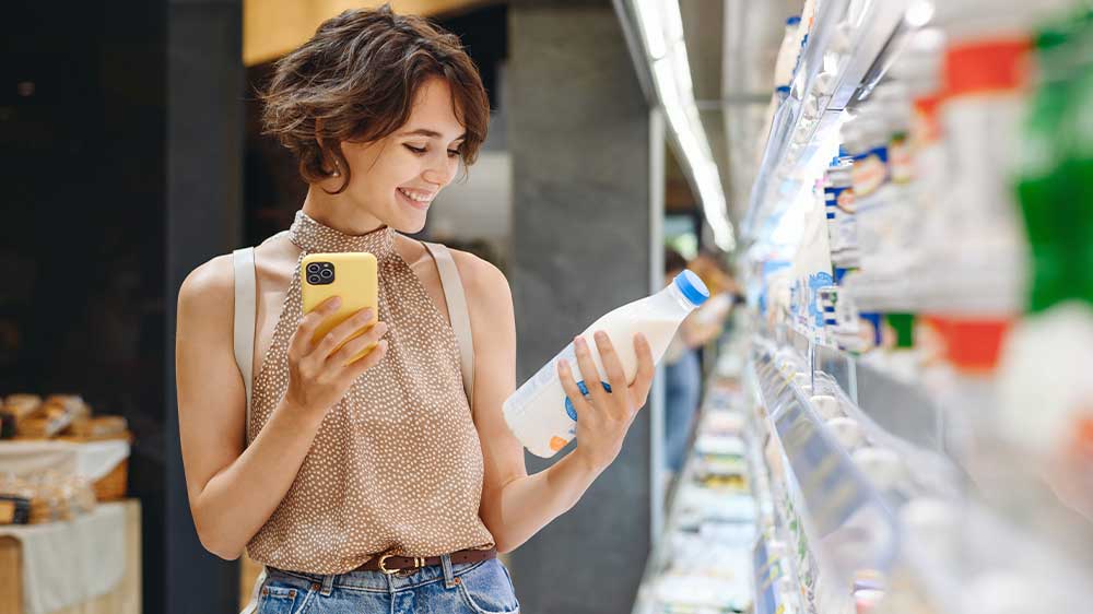 Žena s mobilem vybírá potraviny v supermarketu_06