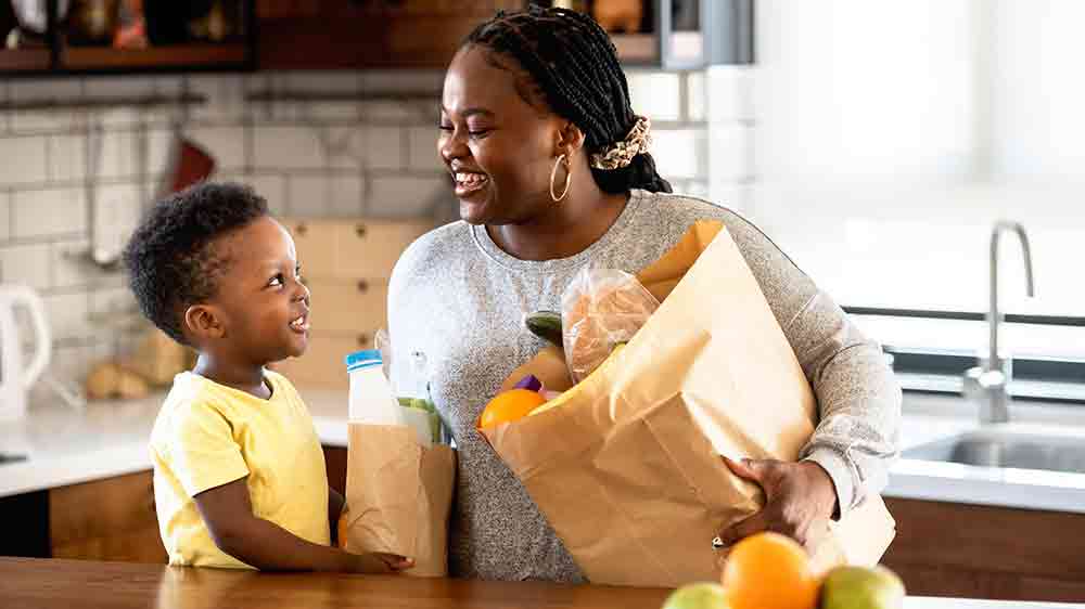 Žena s dítětem vytahující potraviny z nákupní tašky_03