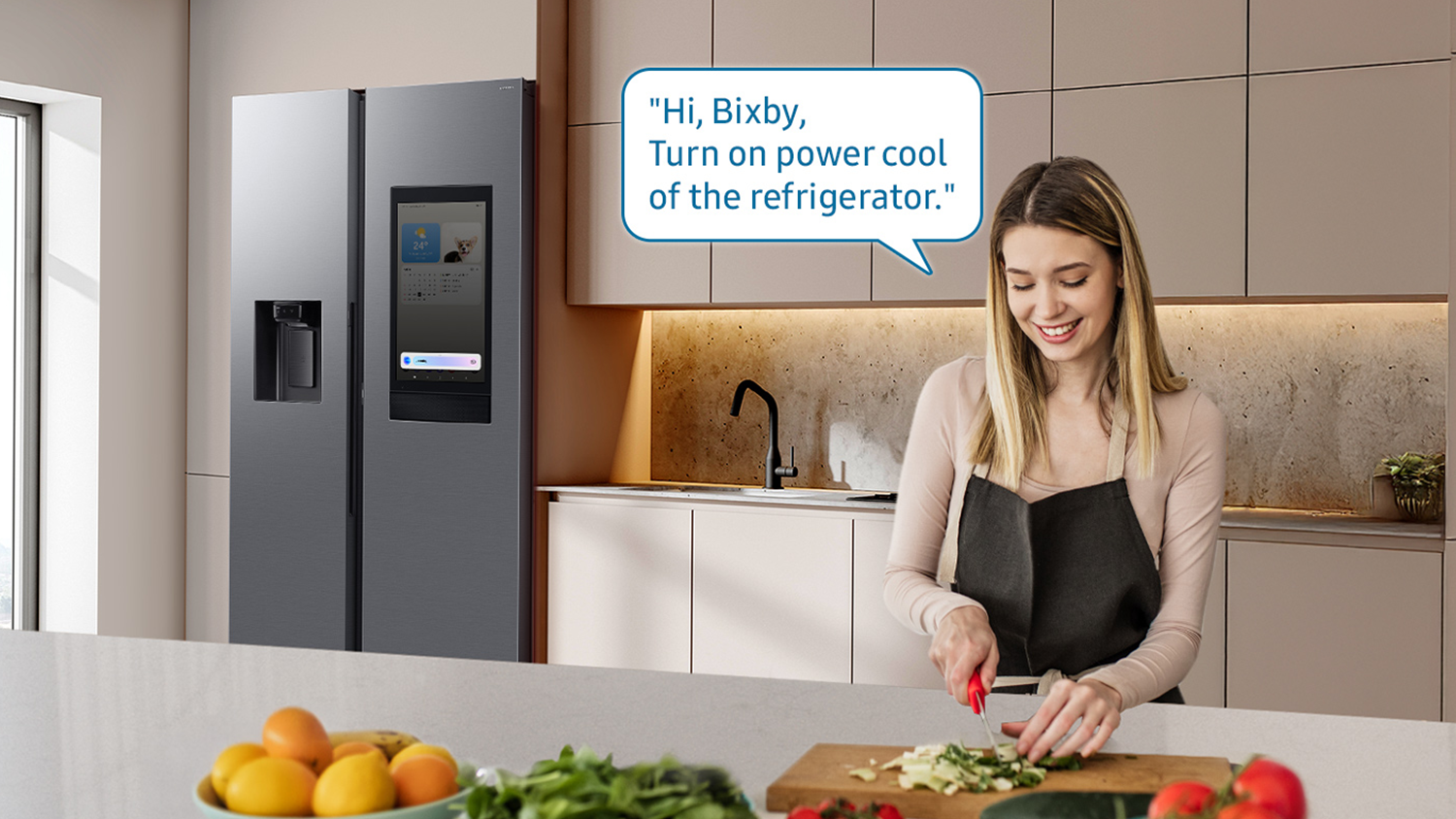 Žena na fotce ovl&aacute;d&aacute; lednici pomoc&iacute; hlasov&eacute;ho asistenta Samsung Bicby
