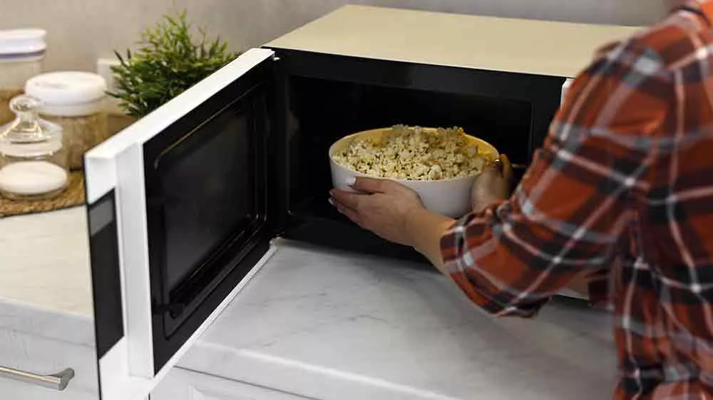 Žena vyndává popcorn z mikrovlnné trouby_02