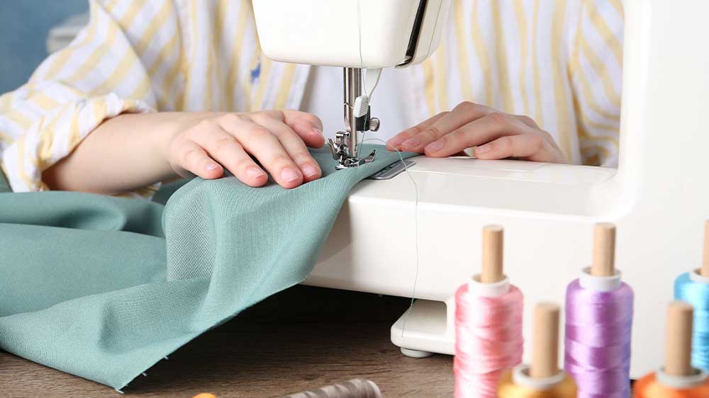 Žena šije oděv na šicím stroji_03