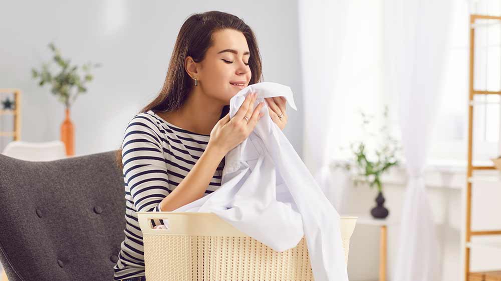 Šťastná žena čichá k čistému prádlu_03