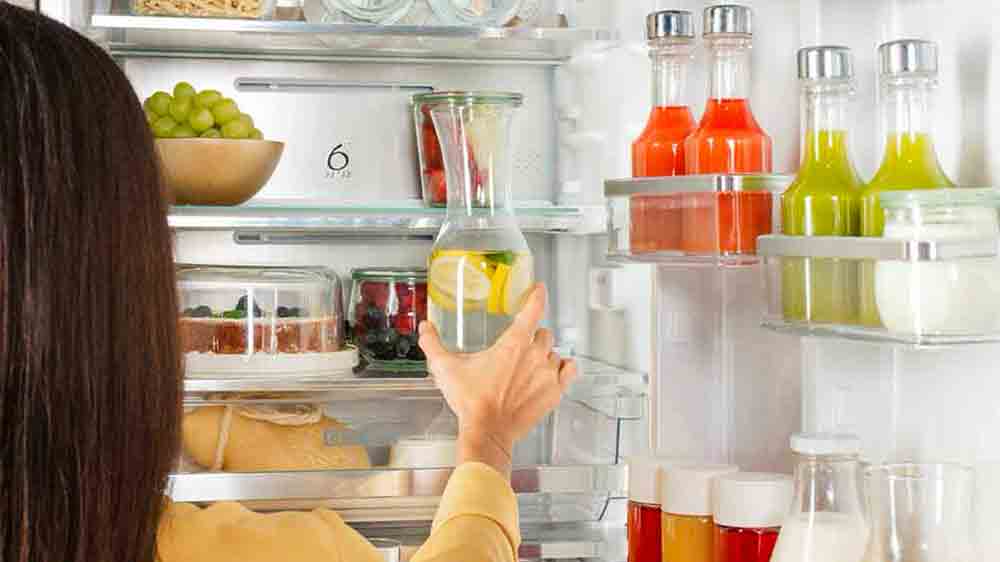 Žena vkl&aacute;d&aacute; karafu s vodou do lednice Whirlpool_03