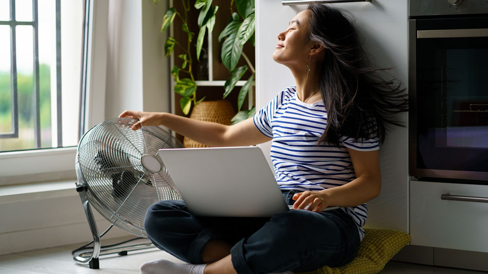 Žena se ovívá podlahovým ventilátorem_03