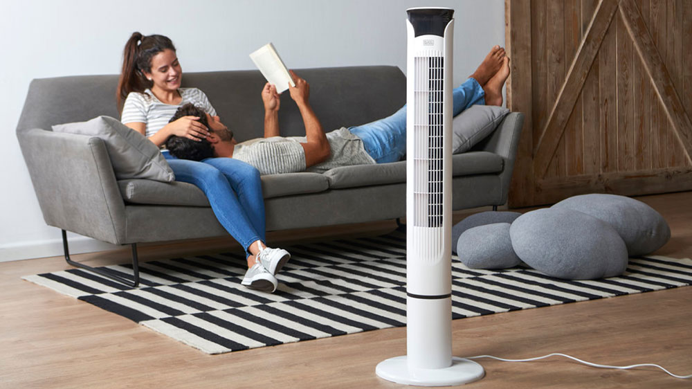 Žena s mužem na gauči vedle sloupov&eacute;ho ventil&aacute;toru Black+Decker BXEFT49E_02