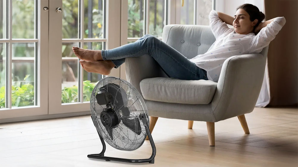 Žena sedí u podlahového ventilátoru Black+Decker BXEFF122E_02