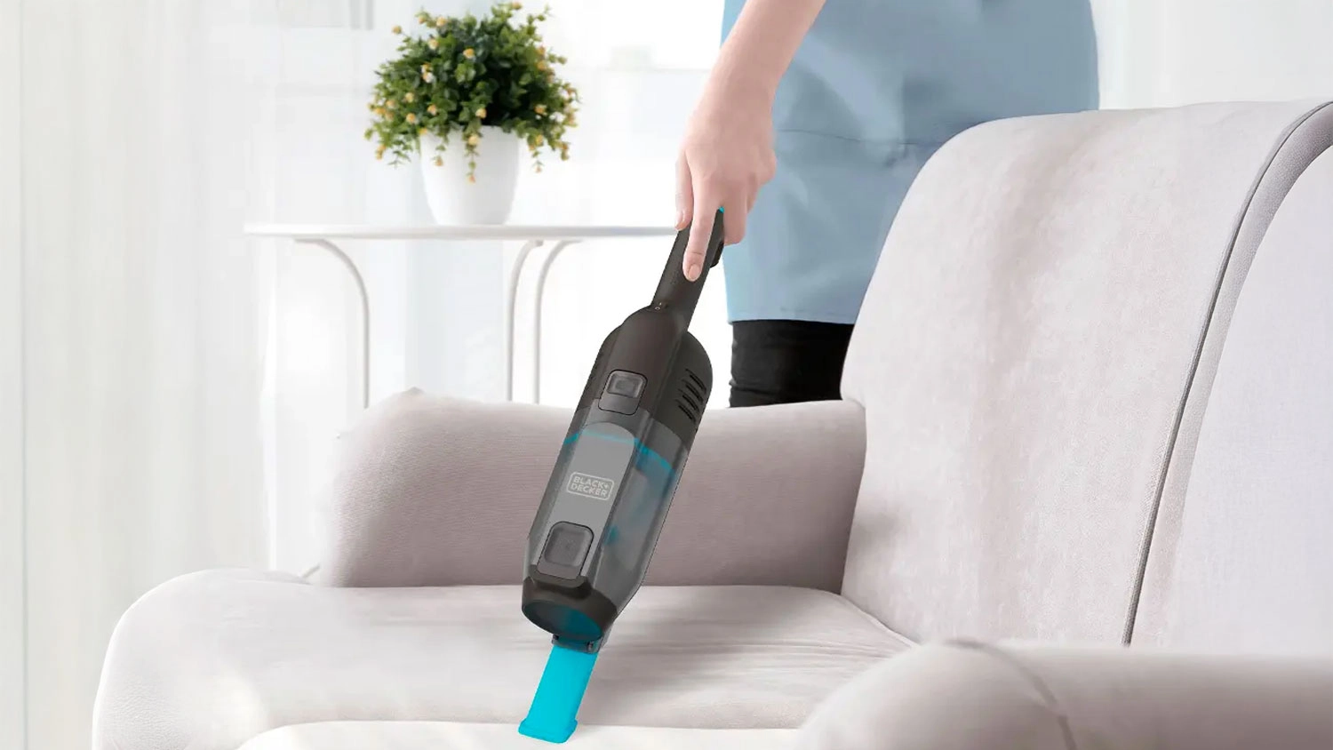 Žena vysává ručním vysavačem Black + Decker BXVMS601E