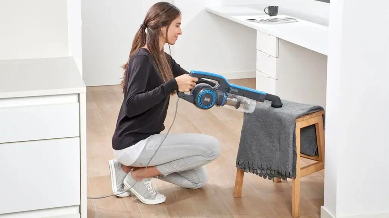 Žena při úklidu domácnosti s vysavačem Black&Decker