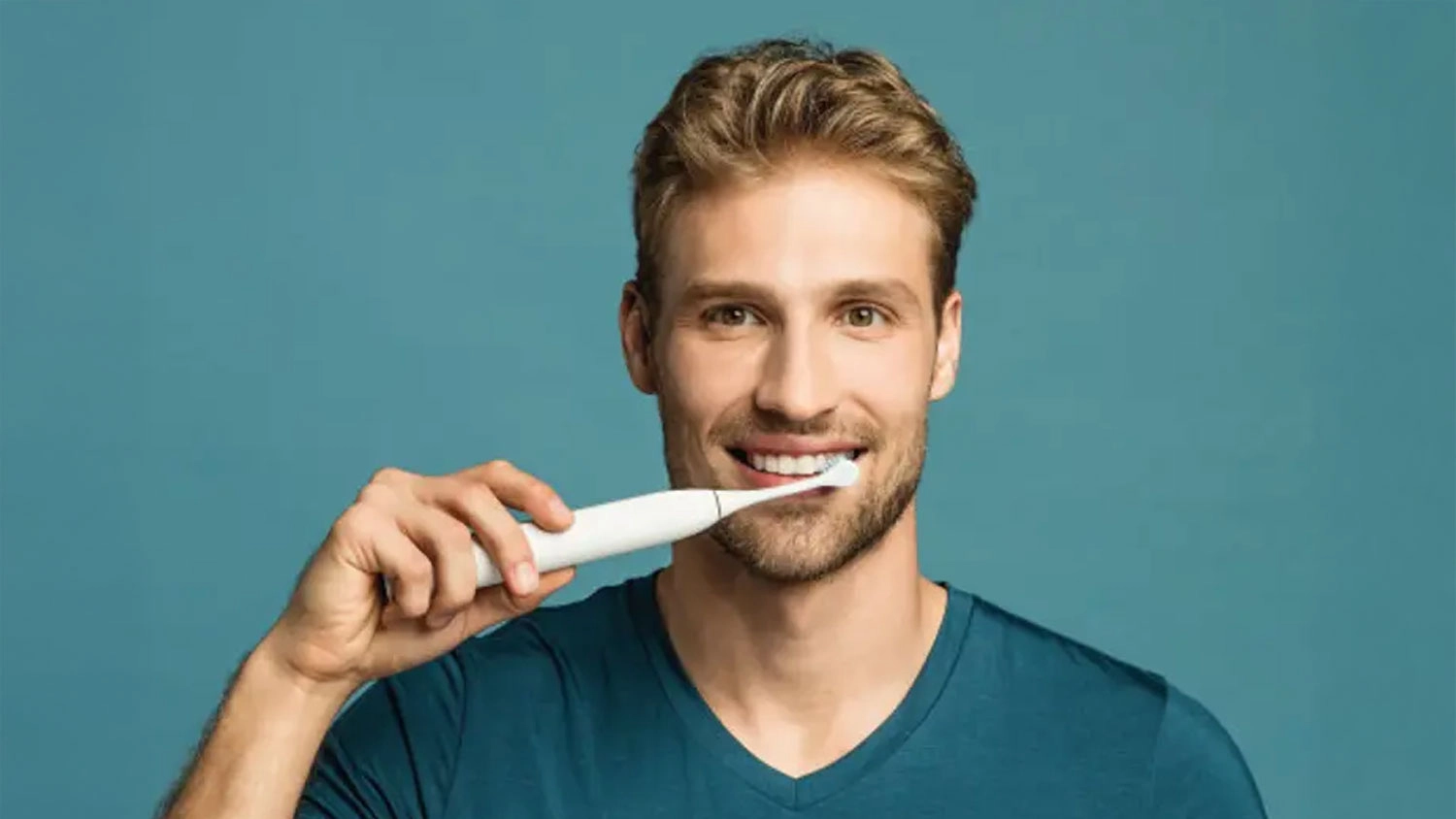 Muž v modrom tričku si čist&iacute; zuby zubnou kefkou Curaprox Hydrosonic PRO Power