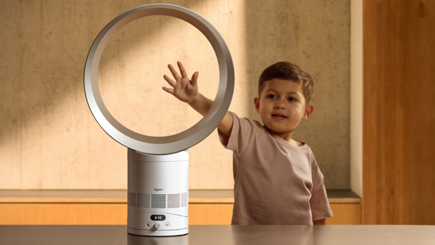 D&iacute;tě natahuje ruku k ventil&aacute;toru Dyson s ovl&aacute;d&aacute;n&iacute;m