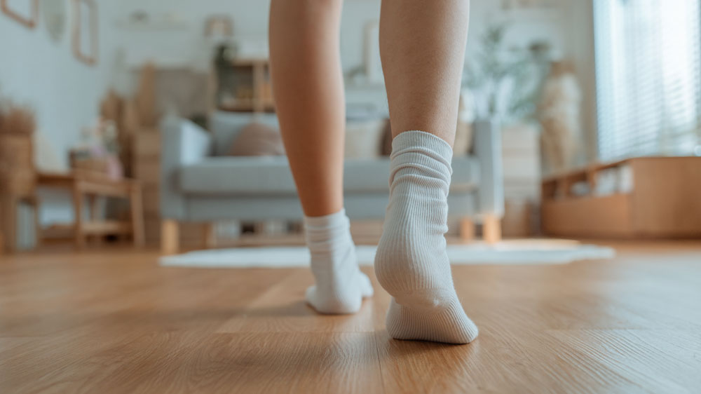Žena v b&iacute;l&yacute;ch ponožk&aacute;ch jde po čist&eacute; podlaze_02