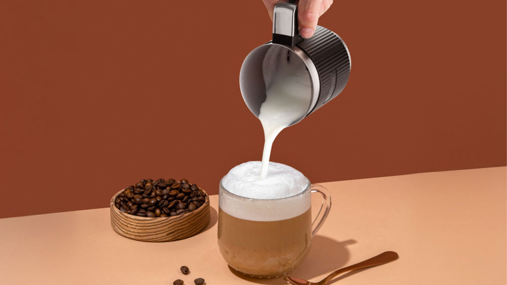 Muž nalieva mlieko do kávy z napeňovača mlieka ETA Cremeo_02