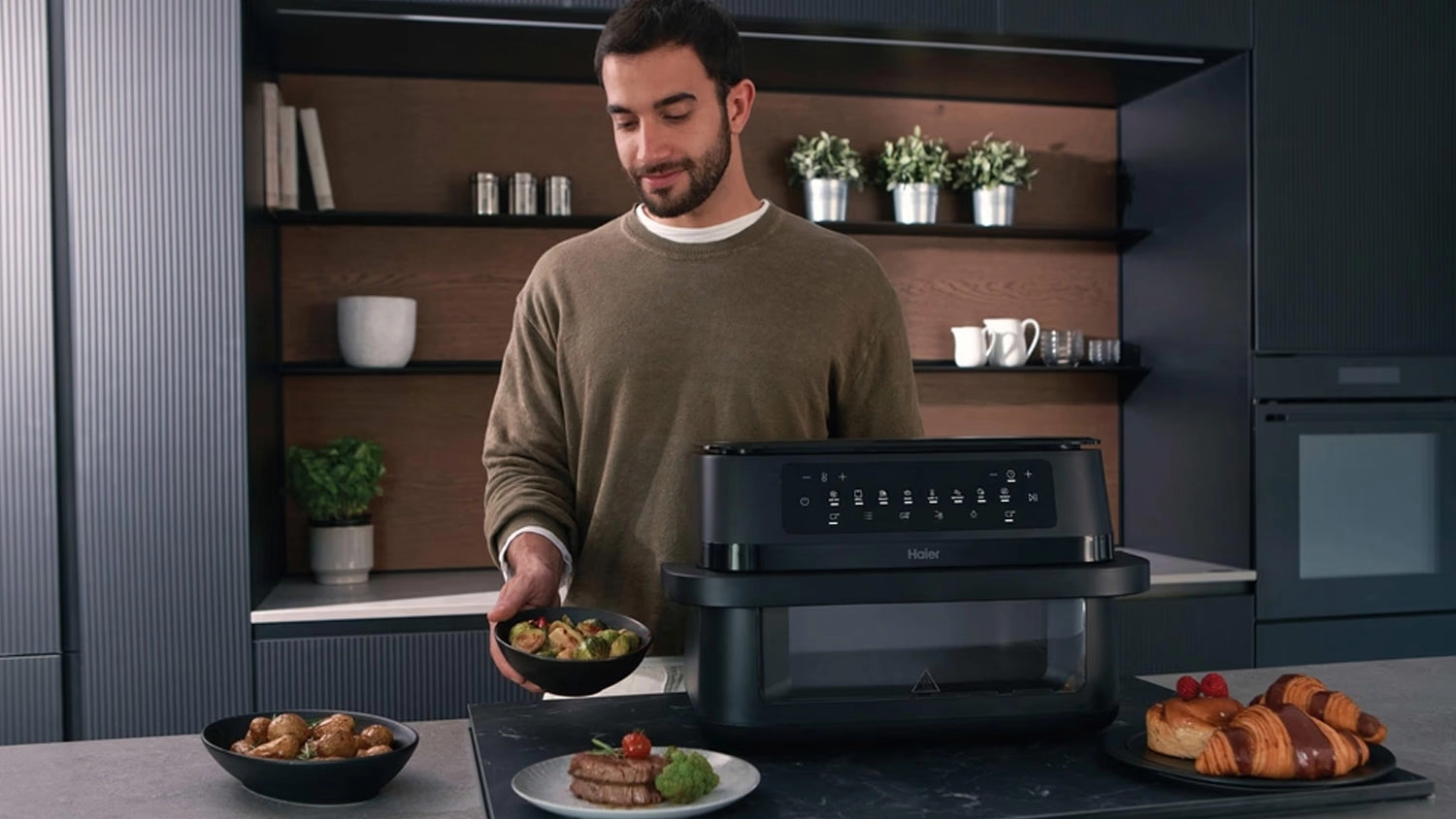 Muž s jídlem připraveným v horkovzdušné fritéze Haier HAF3ADW 011