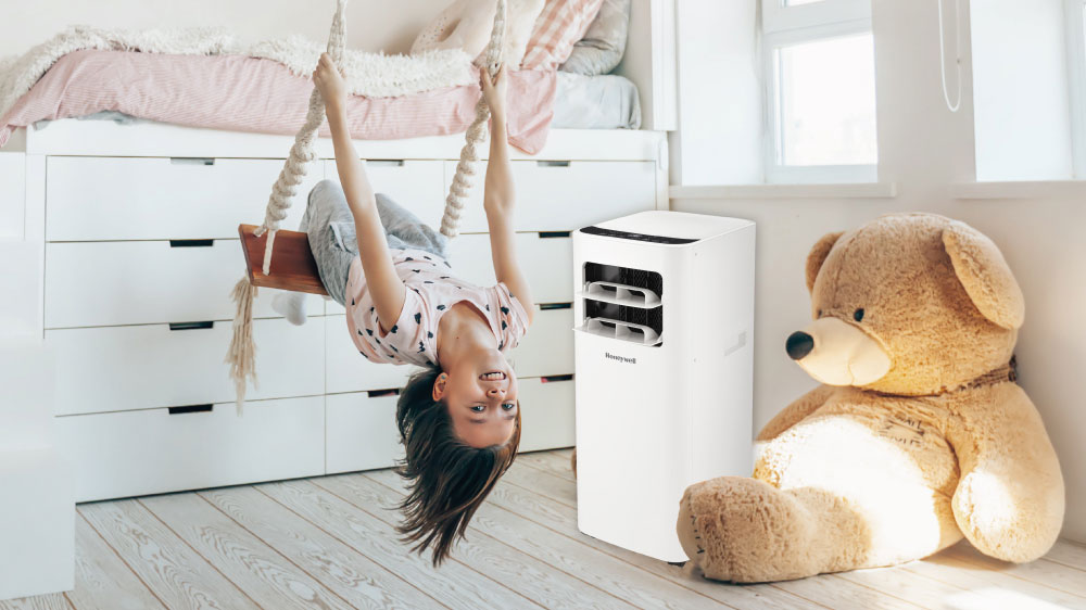 Vesel&aacute; holčička je na houpačce vedle ochlazovače Honeywell v dětsk&eacute;m pokoji_02