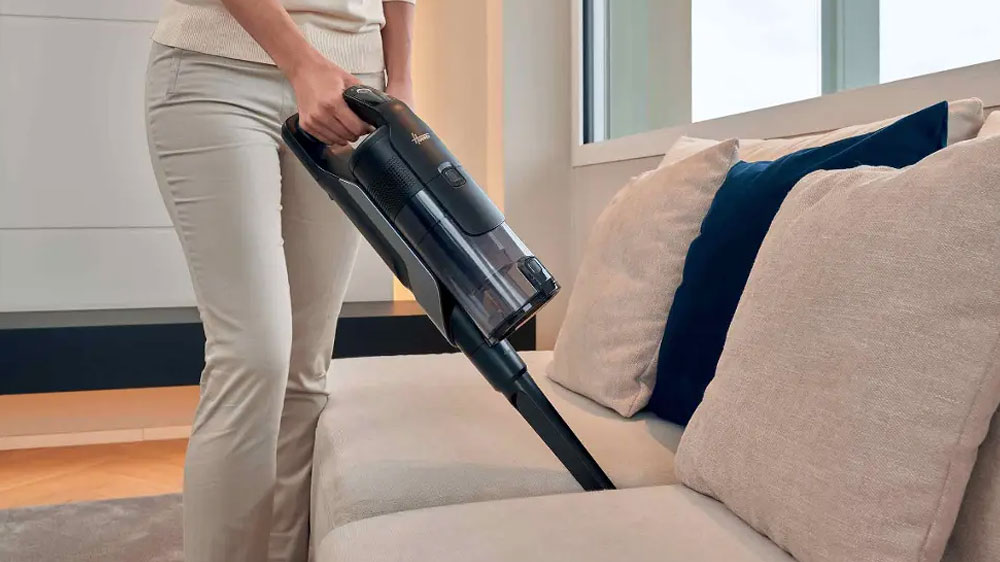 Žena vysávající pohovku s vysavačem Hoover HF610H_02