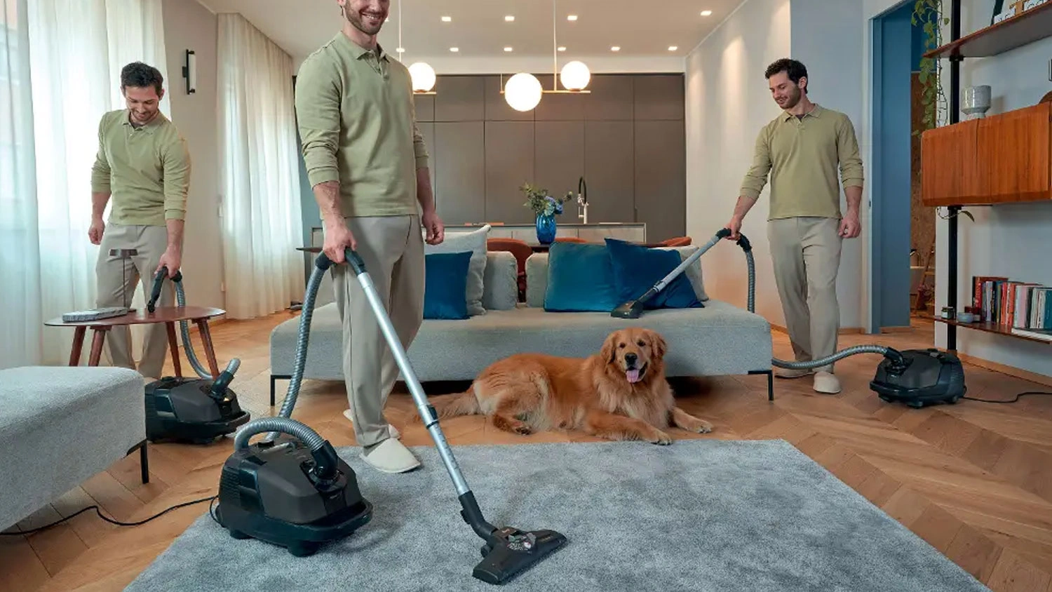Muž vysává sáčkovým vysavačem Hoover HE210P 011 koberec, stůl i sedačku