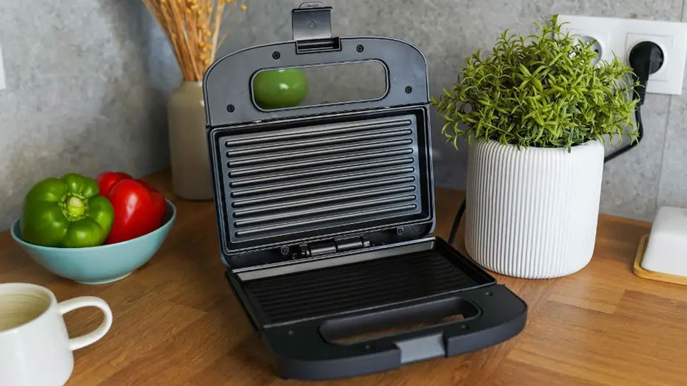 Otvorený sendvičovač Huslog AK-180249 čierny položený na kuchynskej linke_02