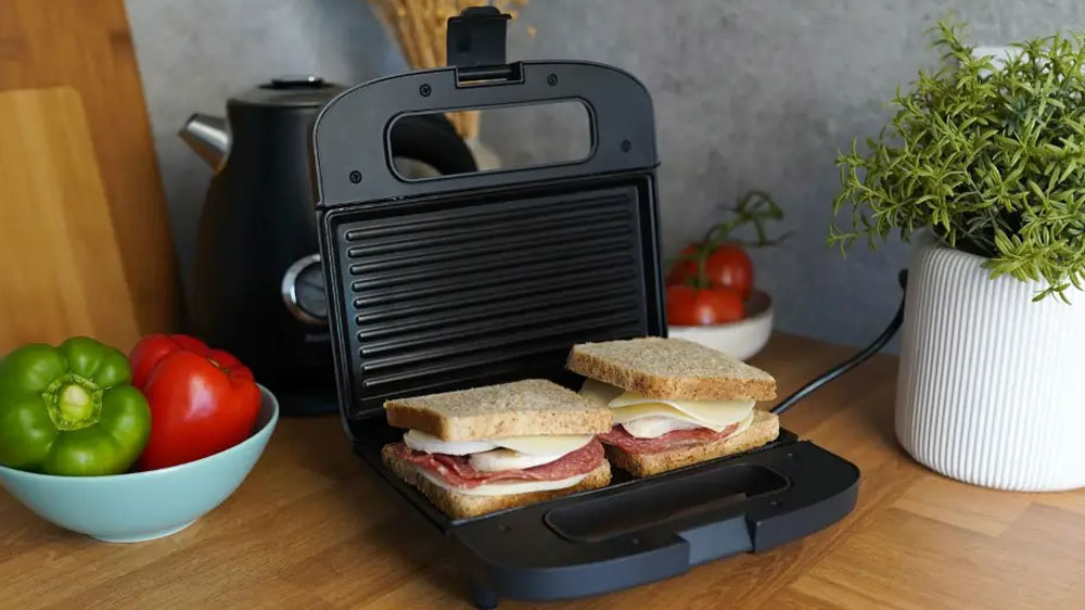 Otvorený sendvičovač Huslog AK-180249 stojaci na kuchynskej linke s naplnenými sendvičmi vo vnútri_03