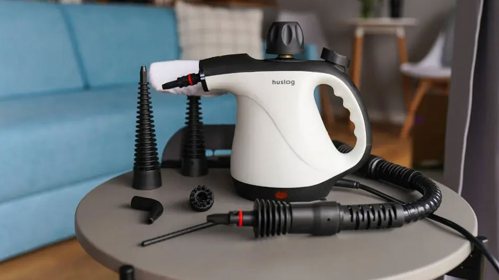 Parní čistič Huslog AD-0948 položený na stole v obývacím pokoji_03