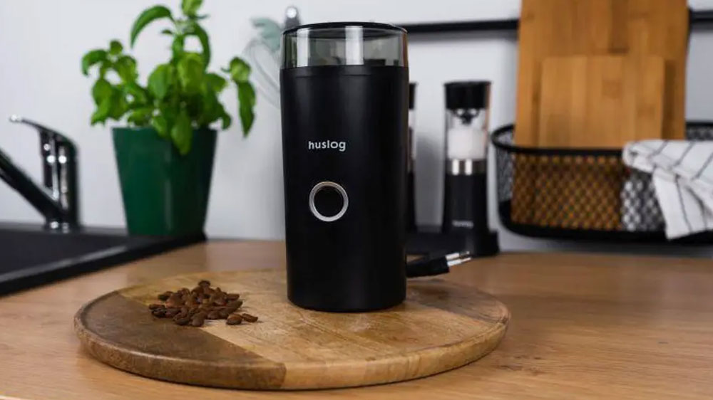 Kávomlýnek Huslog HUS1009 černý postavený na dřevěném prkénku s hromádkou kávových zrn_02