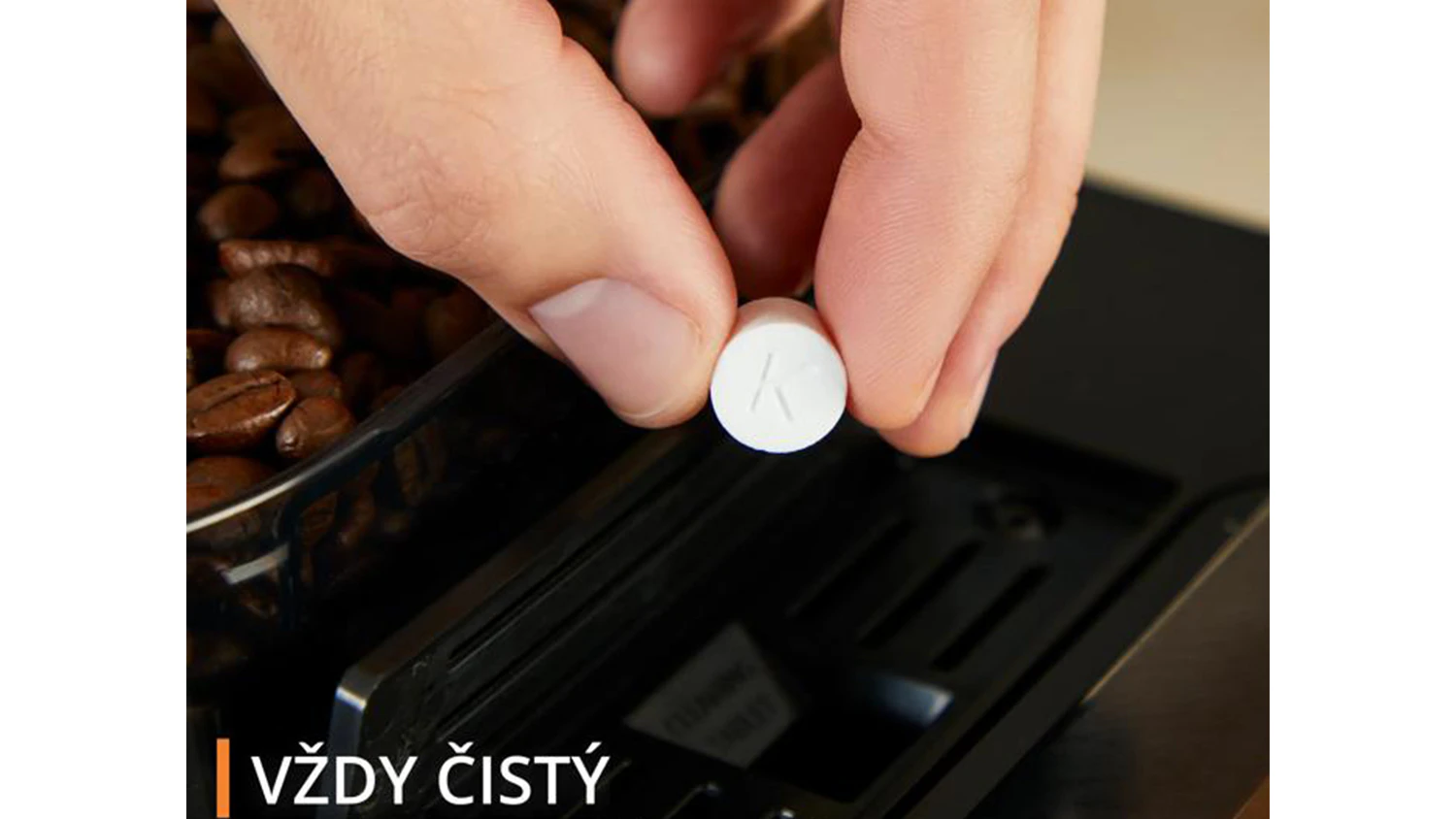 Ruka vkl&aacute;d&aacute; čistic&iacute; tabletu do k&aacute;vovaru