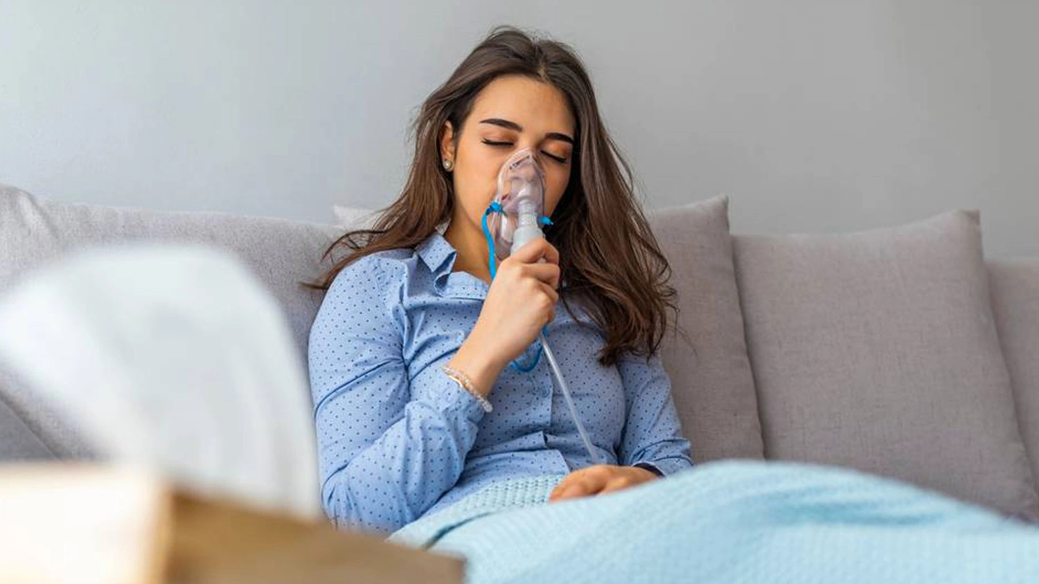 Žena v posteli inhaluje pomoc&iacute; inhal&aacute;tou Laica NE2015