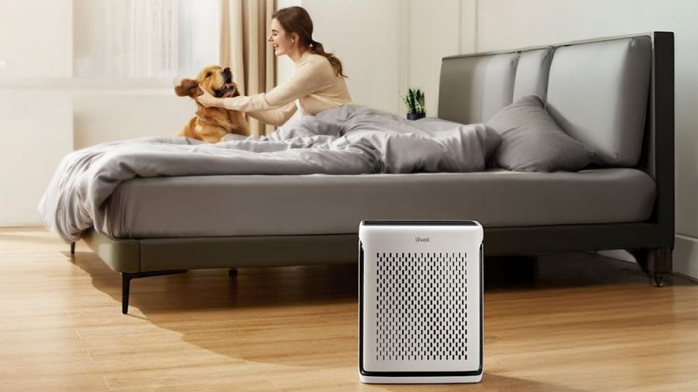 Inteligentní čistička vzduchu Levoit Vital 100S PRO SMART u postele, ve které je žena a pes_02