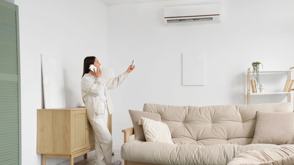 Telefonující žena ovládající klimatizaci dálkovým ovladačem_02