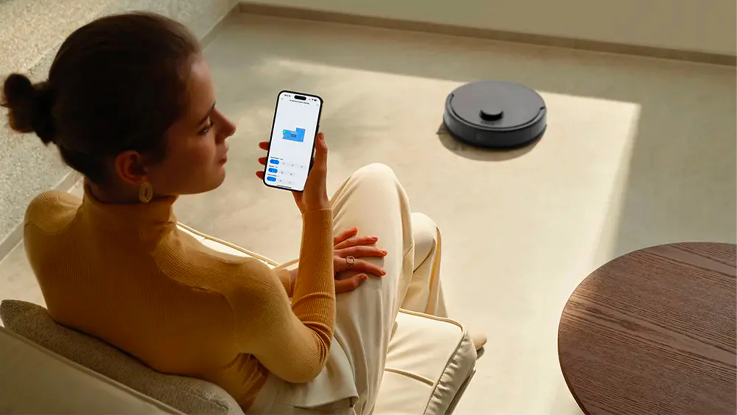 Žena ovládá robotický vysavač MOVA E20 z mobilního telefonu