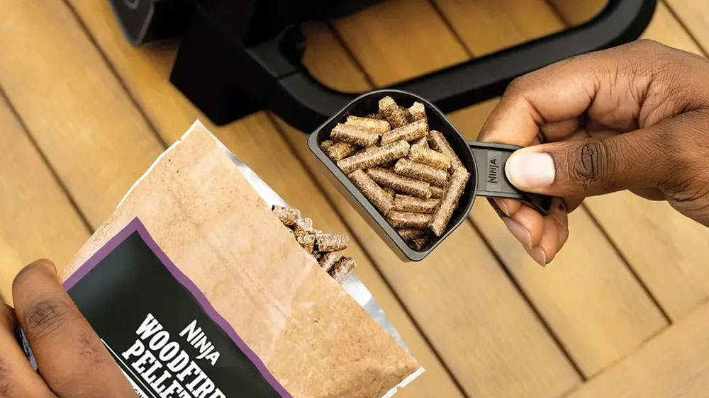 Přidávání 1 odměrky pelet do elektrického venkovního grilu Ninja OG701EU Woodfire_03