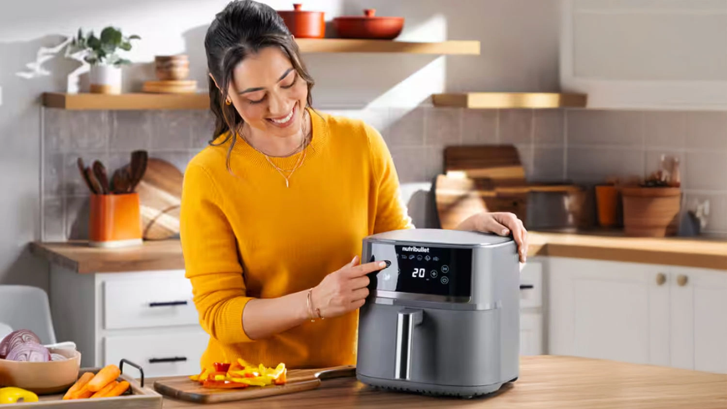 Žena nastavuje displej na fritéze Nutribullet NBA0611DG CrispLite