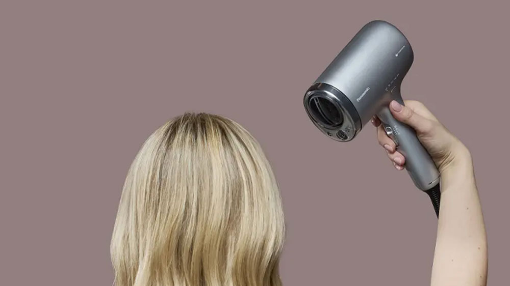 Žena sušiaca si vlasy pomocou fénu Panasonic EH-NA9N-H825_02