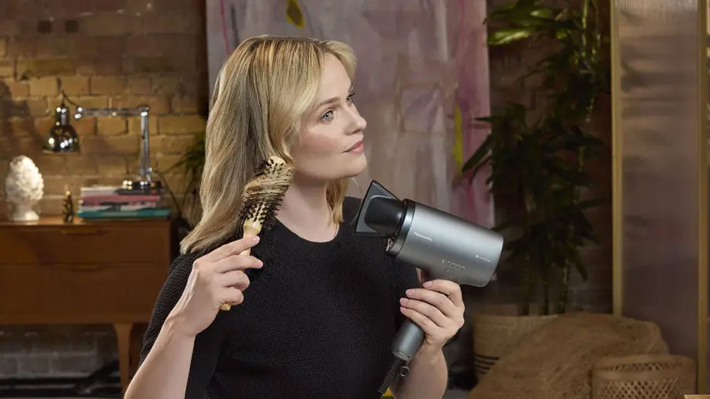 Žena upravujúca si účes pomocou fénu na vlasy Panasonic EH-NA9N-H825_03