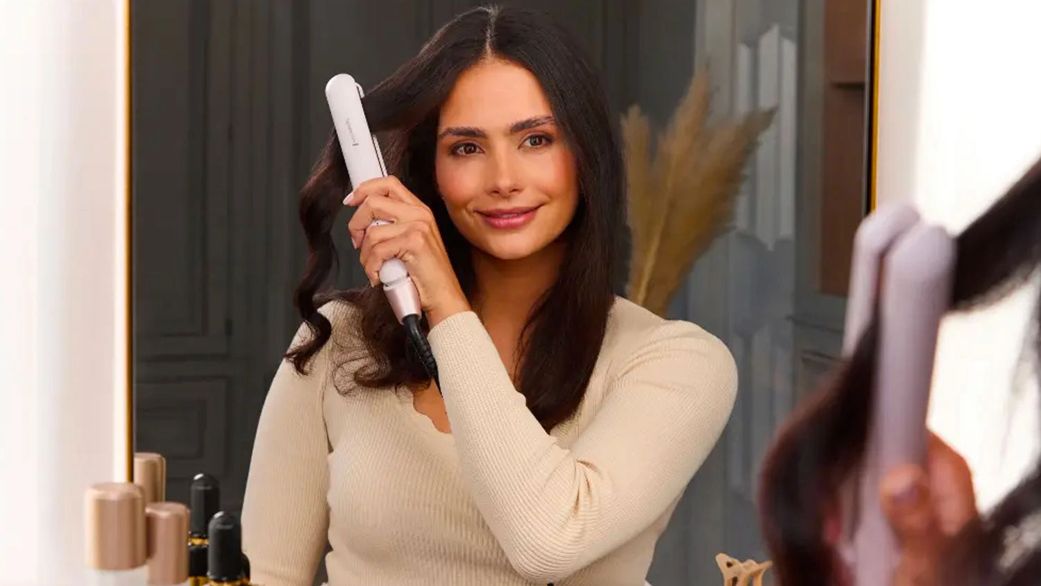 Žena si upravuje vlasy žehličkou na vlasy Remington S4807
