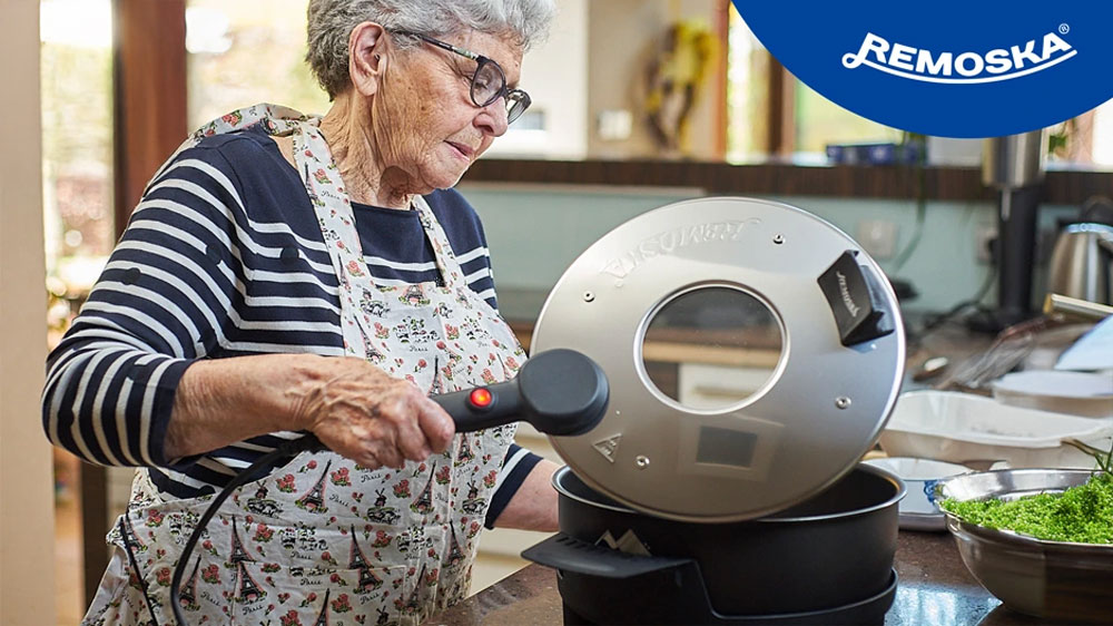 Žena kontroluje obsah elektrické pečicí pánve Remoska P31F/07 Prima Glass Maria_02